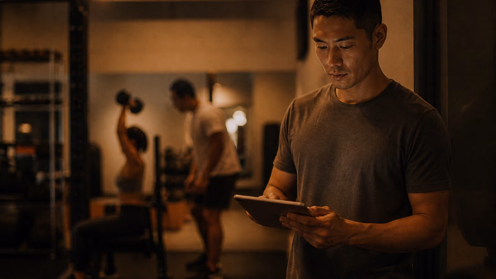 Coach personal training mendampingi member angkat beban di gym